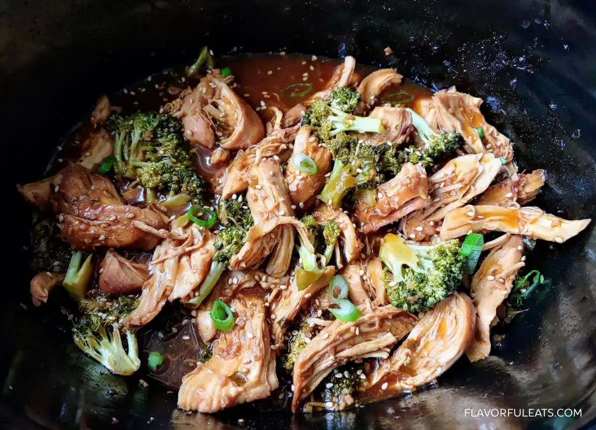 A bowl of food with meat and broccoli.