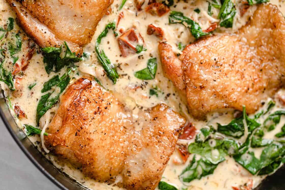 Pan-seared chicken thighs in a creamy sauce with spinach and sun-dried tomatoes.