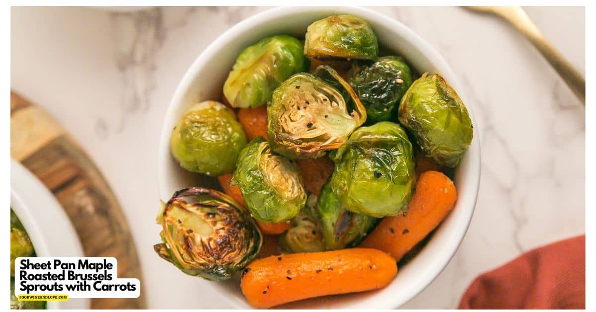 A bowl filled with roasted Brussels sprouts and baby carrots sits on a marble surface.