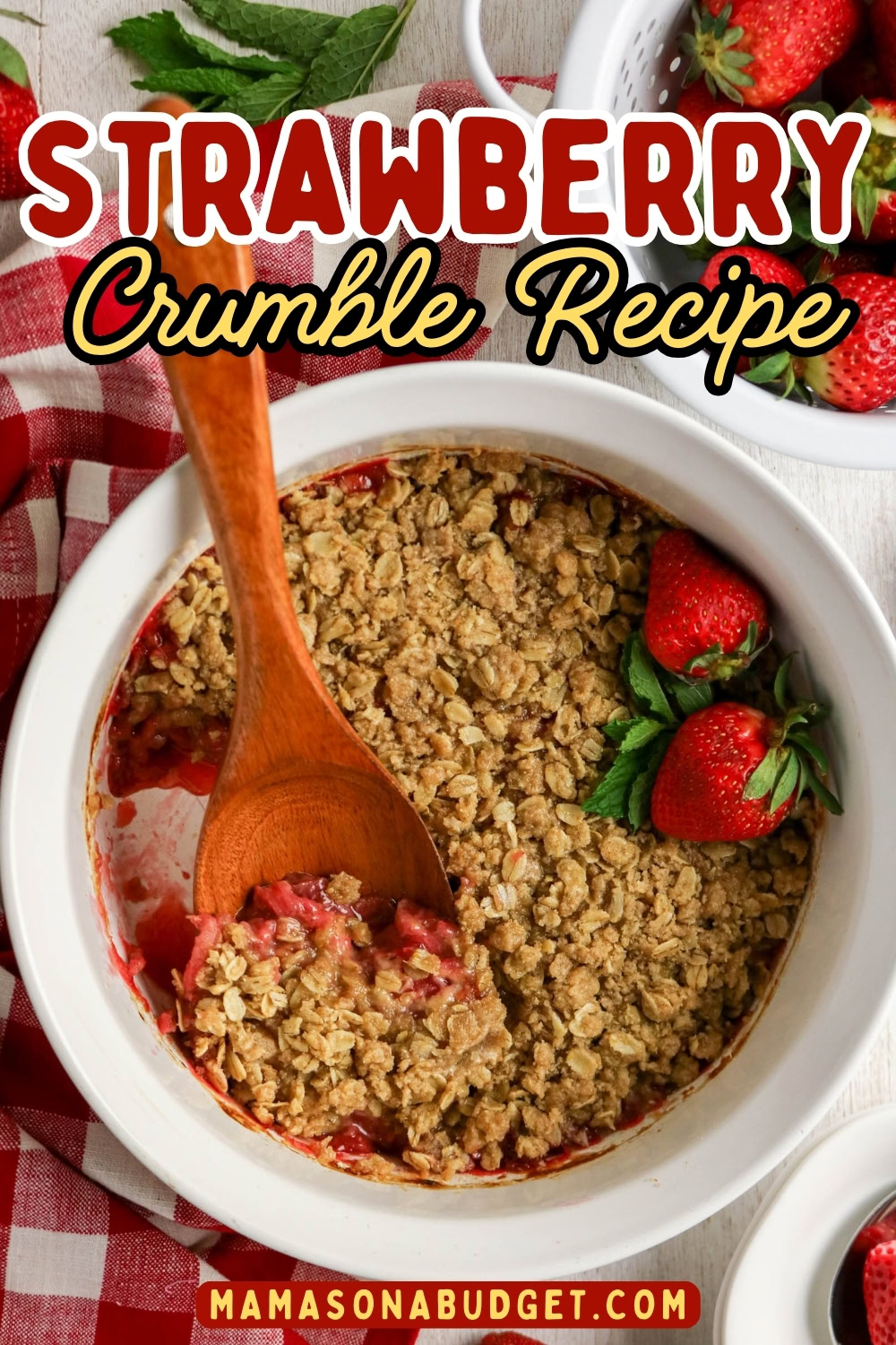 A baking dish of Strawberry Crumble with a wooden spoon, garnished with fresh strawberries; text reads “Strawberry Crumble Recipe.”.