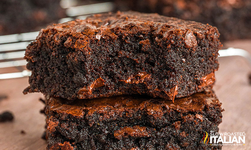 Two thick, chocolate brownies stacked on top of each other with a moist, rich texture and visible melted chocolate chunks.