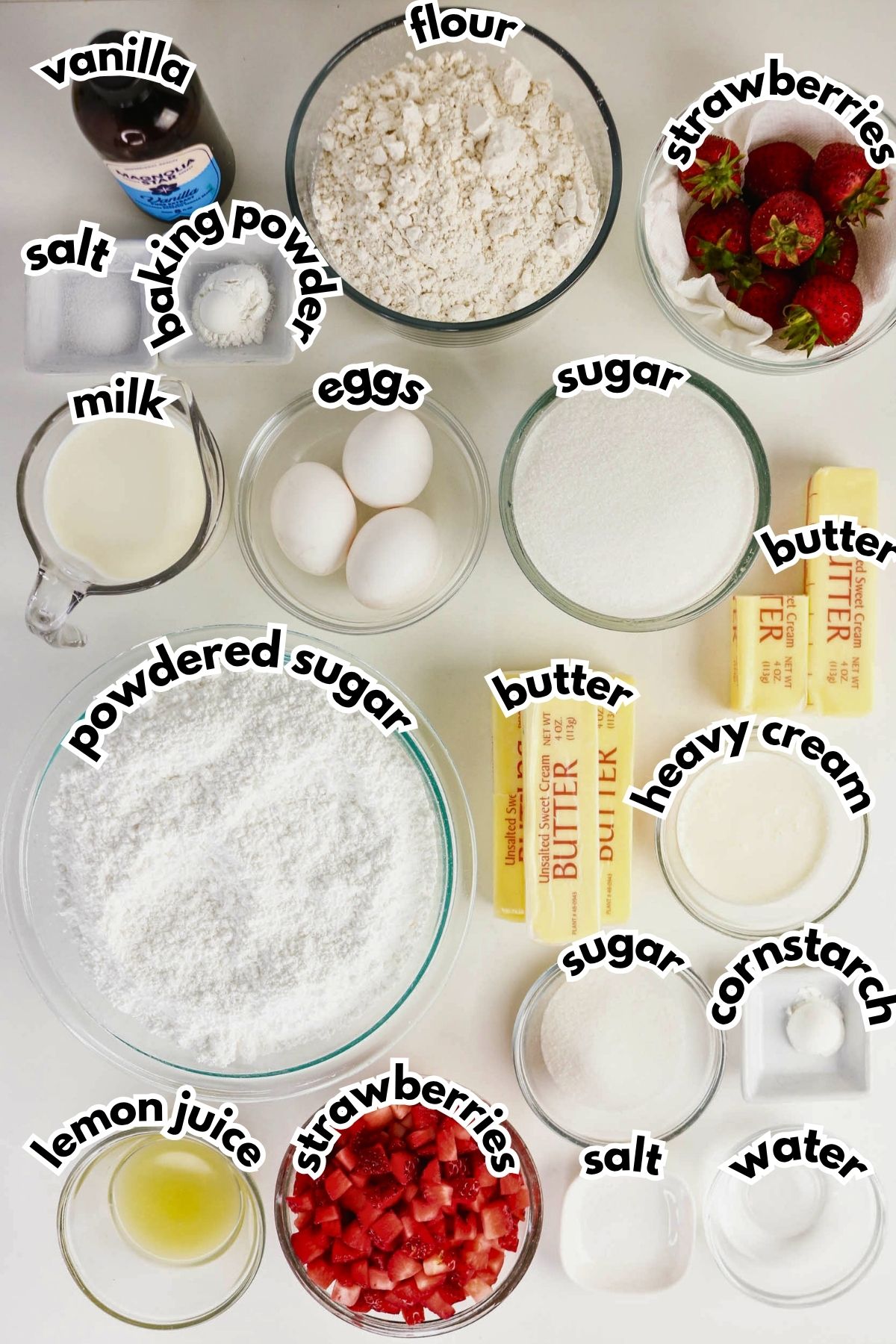 Ingredients for a strawberry shortcake, including flour, sugar, butter, eggs, milk, heavy cream, salt, baking powder, vanilla, lemon juice, strawberries, powdered sugar, cornstarch, and water.