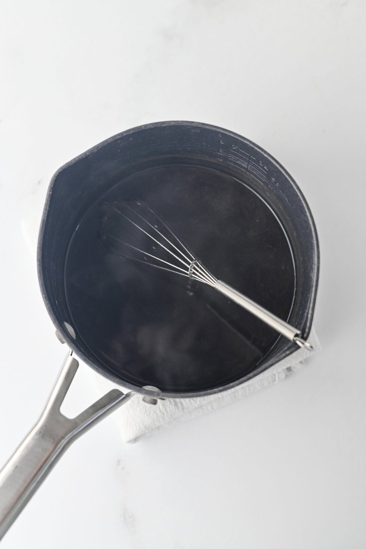 Heating chai tea concentrate in a saucepan on the stove
