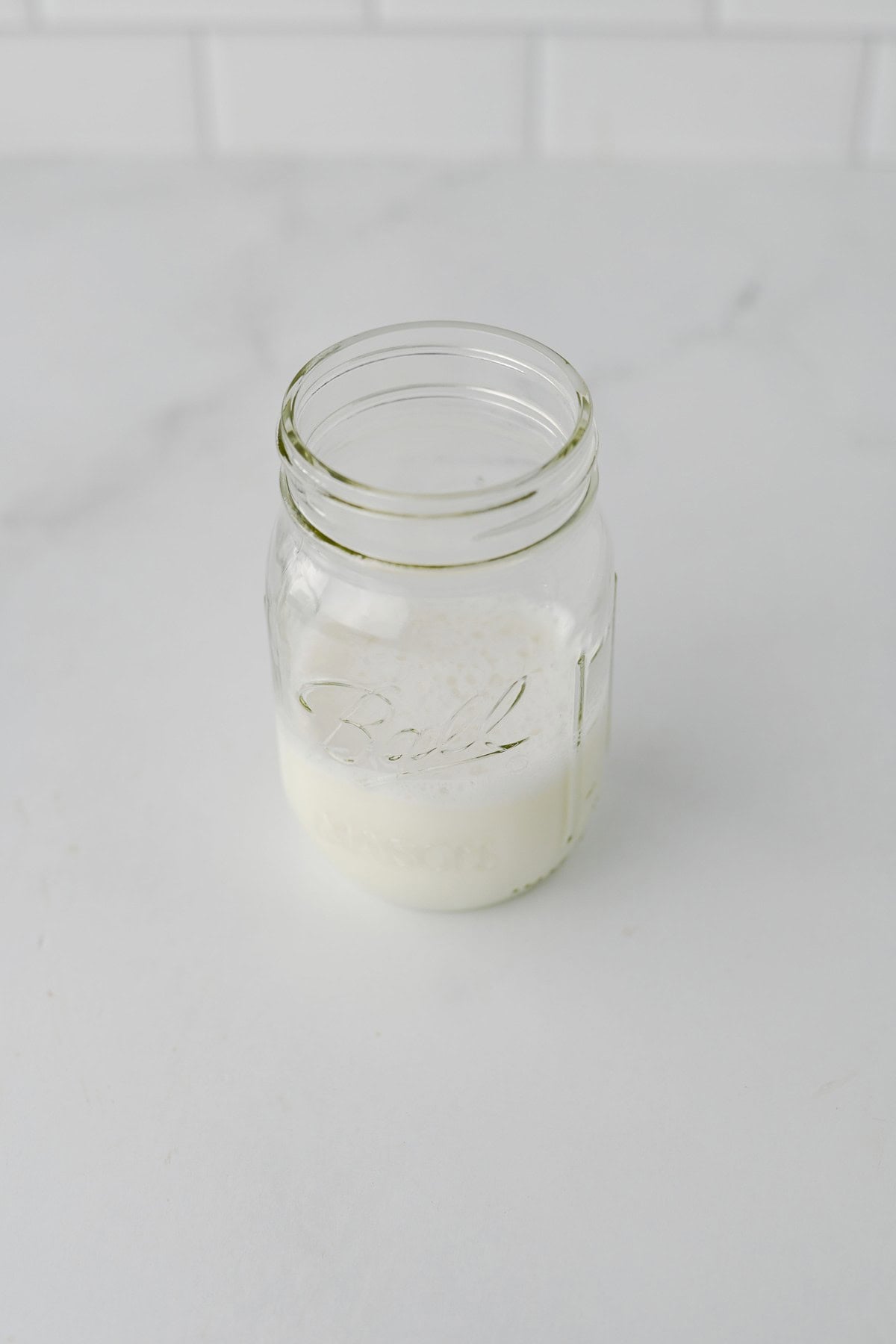 Frothed milk in a Ball mason jar for apple chai latte