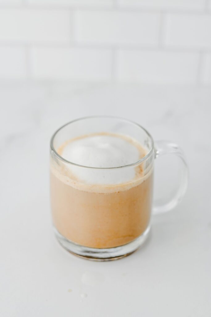Assembled apple chai latte with frothed milk before adding whipped cream topping
